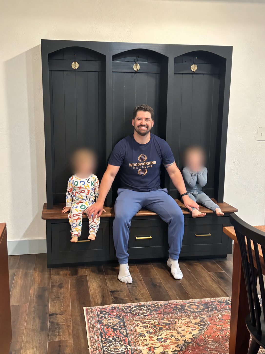 Steve sitting on the finished hall tree with his two sons; their faces are blurred