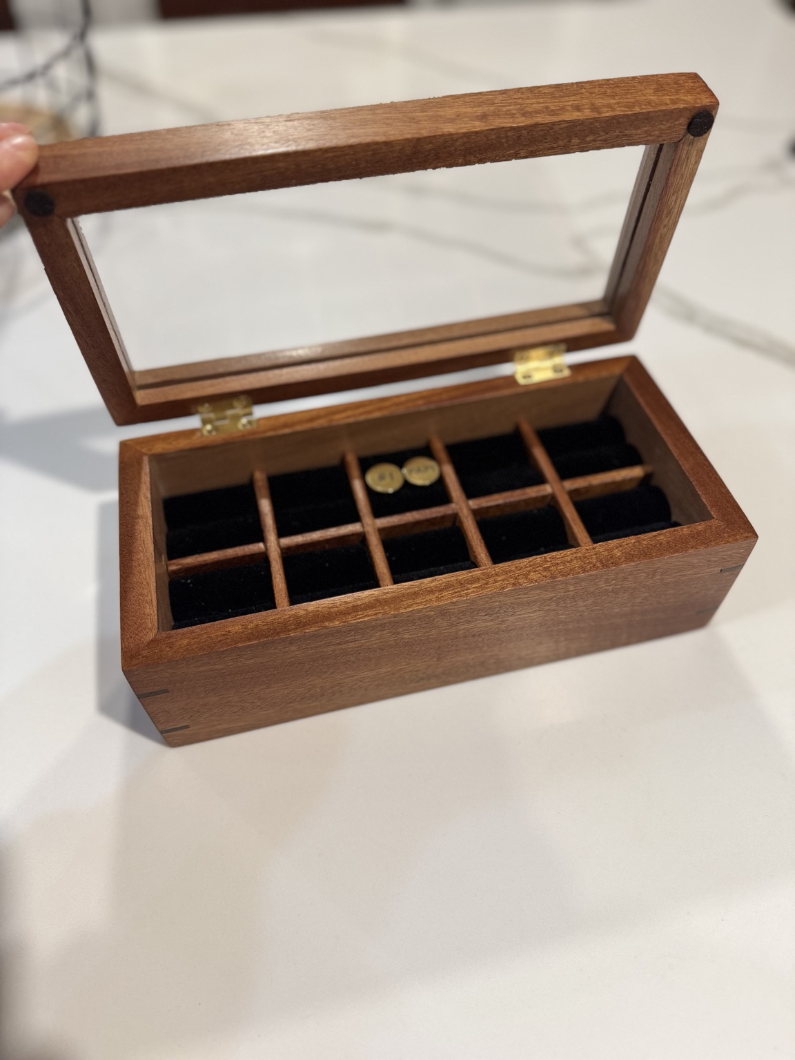 Open wooden keepsake box with a transparent lid and divided black-lined interior